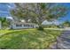 White single story home with lush green lawn and large tree at 39093 Citadel Cir, Zephyrhills, FL 33542