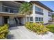 Two-story building with balcony, stairs, and lush landscaping at 4812 Jasper Dr # 105, New Port Richey, FL 34652