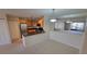 Bright dining area featuring carpet flooring, a modern light fixture, and a partial view of the kitchen at 5764 Baywater Dr # 5764, Tampa, FL 33615