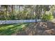 White picket fence surrounds a grassy backyard with mature trees at 6013 Catlin Dr, Tampa, FL 33647