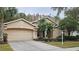 Two-story house with beige exterior, double garage, and palm trees at 6013 Catlin Dr, Tampa, FL 33647