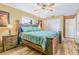 Cozy bedroom featuring wood floors, a ceiling fan, and a large bed with wooden accents at 6321 Staunton Dr, Holiday, FL 34690