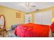 Well-lit bedroom with red bedding and a view of the backyard at 6321 Staunton Dr, Holiday, FL 34690