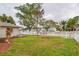 Landscaped side yard with a flagpole and a white picket fence at 6321 Staunton Dr, Holiday, FL 34690