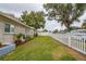 Landscaped side yard with a white fence and mature trees at 6321 Staunton Dr, Holiday, FL 34690