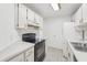 Kitchen features white cabinets, black appliances, and tile floor at 6833 S Wall St, Tampa, FL 33616