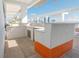 Modern outdoor kitchen with stainless steel appliances, light countertops, and an orange tile accent on the deck at 777 3Rd N Ave # 1605, St Petersburg, FL 33701