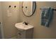 Clean bathroom featuring a pedestal sink and round mirror at 8010 N 11Th St, Tampa, FL 33604