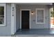 Gray house with a black front door and a porch at 8010 N 11Th St, Tampa, FL 33604