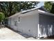 Side view of house with gray siding and landscaping at 8010 N 11Th St, Tampa, FL 33604