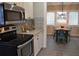 Eat-in kitchen with farmhouse table, updated appliances, and decorative backsplash at 8010 N 11Th St, Tampa, FL 33604