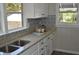 Kitchen features granite countertops, white cabinets, and a double sink at 8010 N 11Th St, Tampa, FL 33604