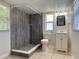 Modern bathroom with tiled walk-in shower, vanity with storage, and natural light at 8153 22Nd N Ave, St Petersburg, FL 33710