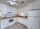 Bright white kitchen featuring white appliances, cabinets, and a tile backsplash at 8153 22Nd N Ave, St Petersburg, FL 33710