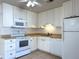Well-maintained kitchen with white cabinetry, appliances, and tile backsplash at 8153 22Nd N Ave, St Petersburg, FL 33710