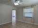 Neutral living room with tile flooring, ceiling fan, and a bright window with white curtain and blinds at 8153 22Nd N Ave, St Petersburg, FL 33710