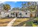 White bungalow with a walkway, landscaping, and mature trees at 1558 13Th S St, St Petersburg, FL 33705