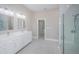 White primary bathroom with a dual sink vanity, large shower, and tile floor at 16117 Medrick Rd, Brooksville, FL 34614