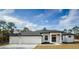 White single-story home with dark gray roof and double garage at 16117 Medrick Rd, Brooksville, FL 34614
