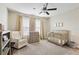 Bedroom with crib, dresser, and comfortable armchair at 21361 Snowy Orchid Ter, Land O Lakes, FL 34637