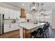 Eat-in kitchen with island, white cabinets, and black accents at 21361 Snowy Orchid Ter, Land O Lakes, FL 34637