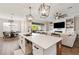 Open concept kitchen with island, white cabinets, and stainless steel appliances at 21361 Snowy Orchid Ter, Land O Lakes, FL 34637