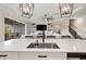 Kitchen island with sink, stainless steel faucet, and view of living room at 21361 Snowy Orchid Ter, Land O Lakes, FL 34637
