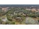 Aerial view of a residential area with houses, trees, and a small pond at 2376 Meadow Lark Rd, Spring Hill, FL 34608