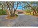 Front view of a single-story home with a circular driveway and mature trees at 2376 Meadow Lark Rd, Spring Hill, FL 34608