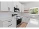 Modern kitchen with white cabinets, stainless steel appliances, and quartz countertops at 4551 Wilcox Ave, North Port, FL 34288