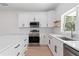 Modern kitchen with white cabinets, stainless steel appliances, and quartz countertops at 4551 Wilcox Ave, North Port, FL 34288