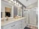 Bathroom with double sinks, white cabinets, and a glass shower at 5021 Gato Del Sol Cir, Wesley Chapel, FL 33544