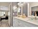 Bathroom with double sinks, white cabinets, and a view to the bedroom at 5021 Gato Del Sol Cir, Wesley Chapel, FL 33544