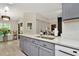 Bright kitchen features white counters, gray cabinets, stainless steel sink and modern finishes at 5021 Gato Del Sol Cir, Wesley Chapel, FL 33544