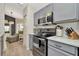 Kitchen with gray cabinets, stainless steel appliances, and a view to the living area at 5021 Gato Del Sol Cir, Wesley Chapel, FL 33544