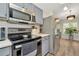 Kitchen with stainless steel appliances, gray cabinets, and wood-look flooring at 5021 Gato Del Sol Cir, Wesley Chapel, FL 33544