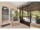 Relaxing screened lanai with comfortable seating, leading to an outdoor gazebo and backyard at 5021 Gato Del Sol Cir, Wesley Chapel, FL 33544