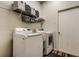 Bright laundry room with a front load washer, dryer and wire shelving for ample storage space at 5021 Gato Del Sol Cir, Wesley Chapel, FL 33544