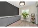 A bright mud room with grey cabinetry, a chandelier and plank flooring at 5021 Gato Del Sol Cir, Wesley Chapel, FL 33544