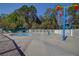 Community splash pad with colorful play features, seating, and safety fencing for Gathering fun at 5021 Gato Del Sol Cir, Wesley Chapel, FL 33544