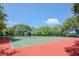 Well-maintained tennis courts surrounded by trees under a sunny sky invite players of all skill levels at 6970A Place De La Paix # 2A, South Pasadena, FL 33707