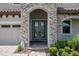 Charming home entrance featuring double glass doors, stone accents, and lush landscaping at 13019 Paddock Wood Pl, Riverview, FL 33579