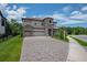 Stunning two-story home with a circular turret, three-car garage, and paved driveway at 13019 Paddock Wood Pl, Riverview, FL 33579