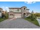 Front exterior view of a two-story home with a three-car garage at 13019 Paddock Wood Pl, Riverview, FL 33579