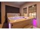 A hot tub with massaging jets and lights is located on a covered patio at 13019 Paddock Wood Pl, Riverview, FL 33579