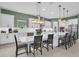 Modern kitchen with white cabinets, large island, stainless steel appliances, and stylish pendant lighting at 13019 Paddock Wood Pl, Riverview, FL 33579