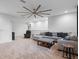 Expansive living room with plush seating, neutral decor, and a striking ceiling fan at 13019 Paddock Wood Pl, Riverview, FL 33579
