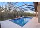 Inviting pool and spa with a fire pit and mature landscaping at 13019 Paddock Wood Pl, Riverview, FL 33579