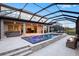 An outdoor screened pool and spa are situated near the home's living area and outdoor kitchen at 13019 Paddock Wood Pl, Riverview, FL 33579