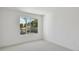 Bright bedroom with neutral carpet, white walls, and a large window with a neighborhood view at 1530 W River Shore Way, Tampa, FL 33603